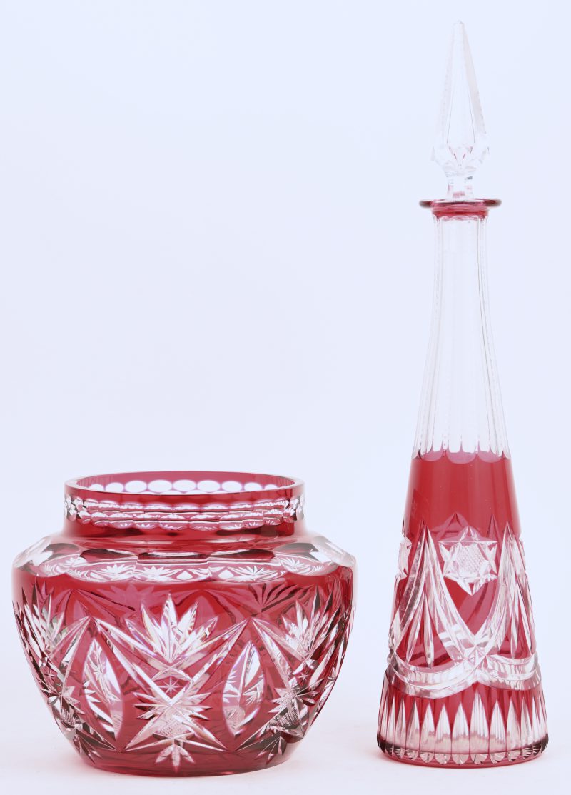 Een Boheeems kristallen karaf en vaas met rood in de massa.
