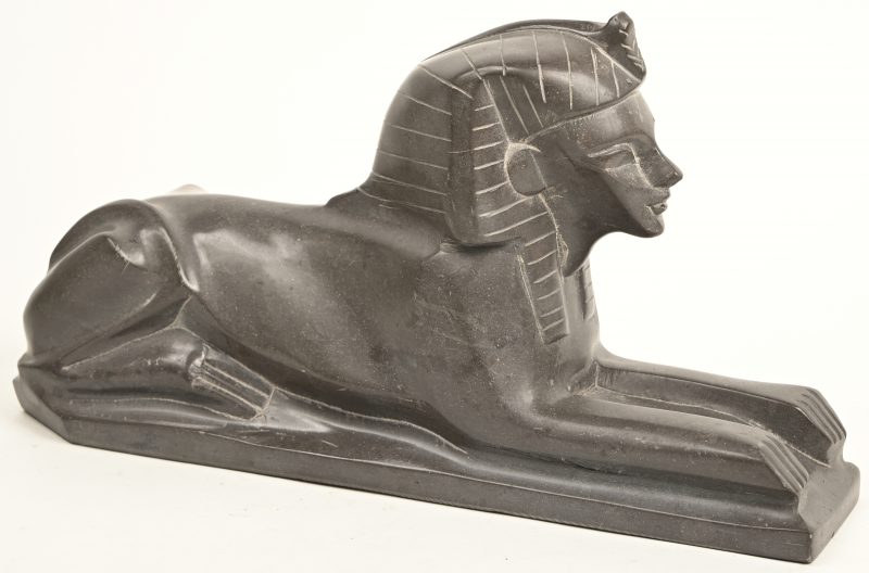 Een grijs marmeren beeld voorstellende een Egyptische Sphinx.