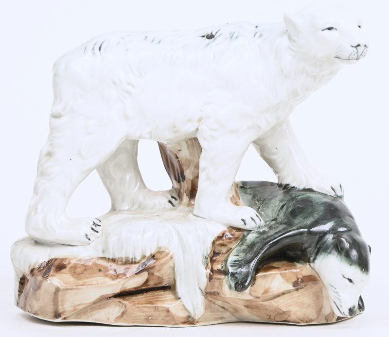 Een porseleinen beeld van een ijsbeer met gevelde zeehond.