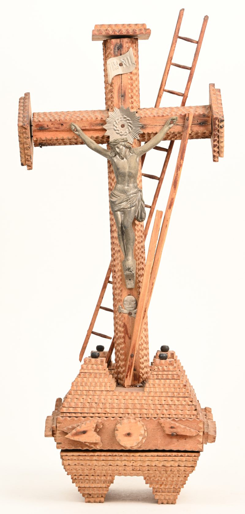 “Jezus aan het kruis”. Een houten tramp art beeldje met corpus uit tin.