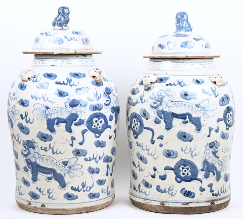 Een paar blauw-wit Chinees porseleinen dekselvazen met mythisch tafereel in het decor.