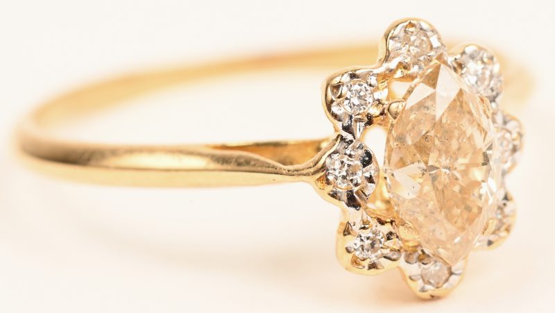 Een 18 karaats geelgouden ring bezet met een cognac kleurige diamant in  markies slijp van +- 0,80 ct. en 8 kleine briljantjes.