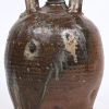 Een oude aardewerken schenkkan met 2 handvatten en schade aan de dop.