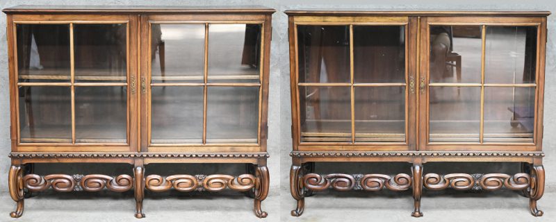 Een set van twee identieke houten, 2 deurs vitrinekasten. Met uitgewerkt onderstel.