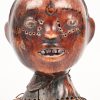 Twee gebeeldhouwe Afrikaanse beeldhouwwerken, bestaande uit een masker met twee personages (beschadiging) en een hoofd, bekleed met leder.