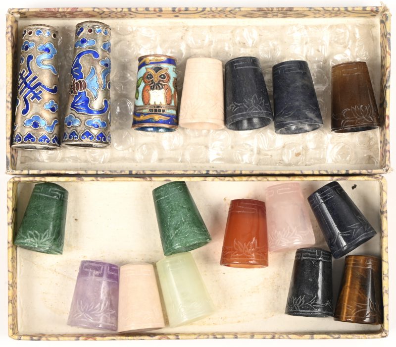 Een serie van 17 diverse vingerhoeden van cloisonné op geel koper en van diverse soorten pietradura. Chinees werk.