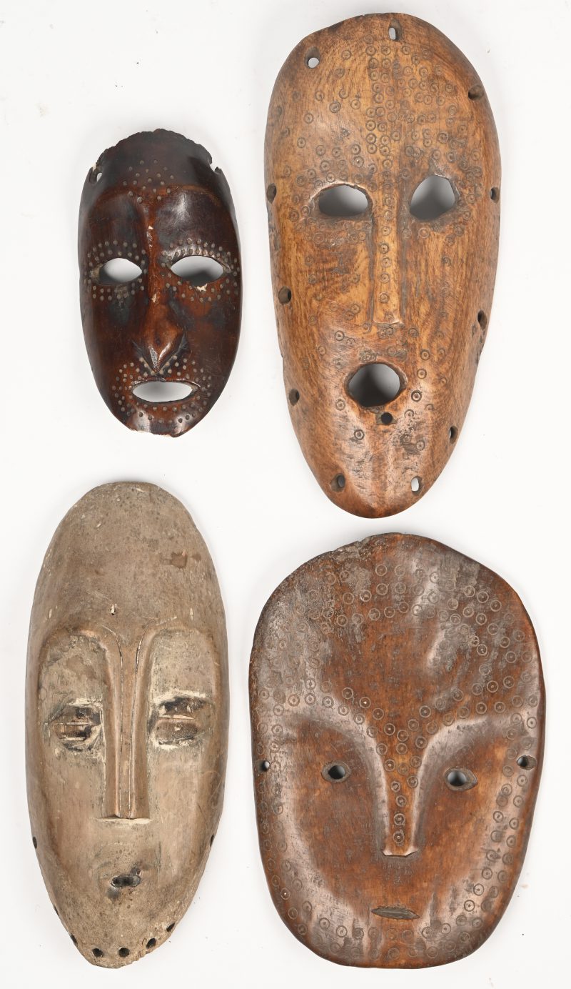 Een lot van 4 platte Afrikaanse hardhouten maskers, gedecoreerd en voorzien van gaten.