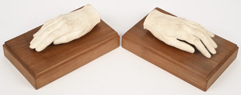 Een set van 2 plaasteren afgietsels van handen op houten blokken.