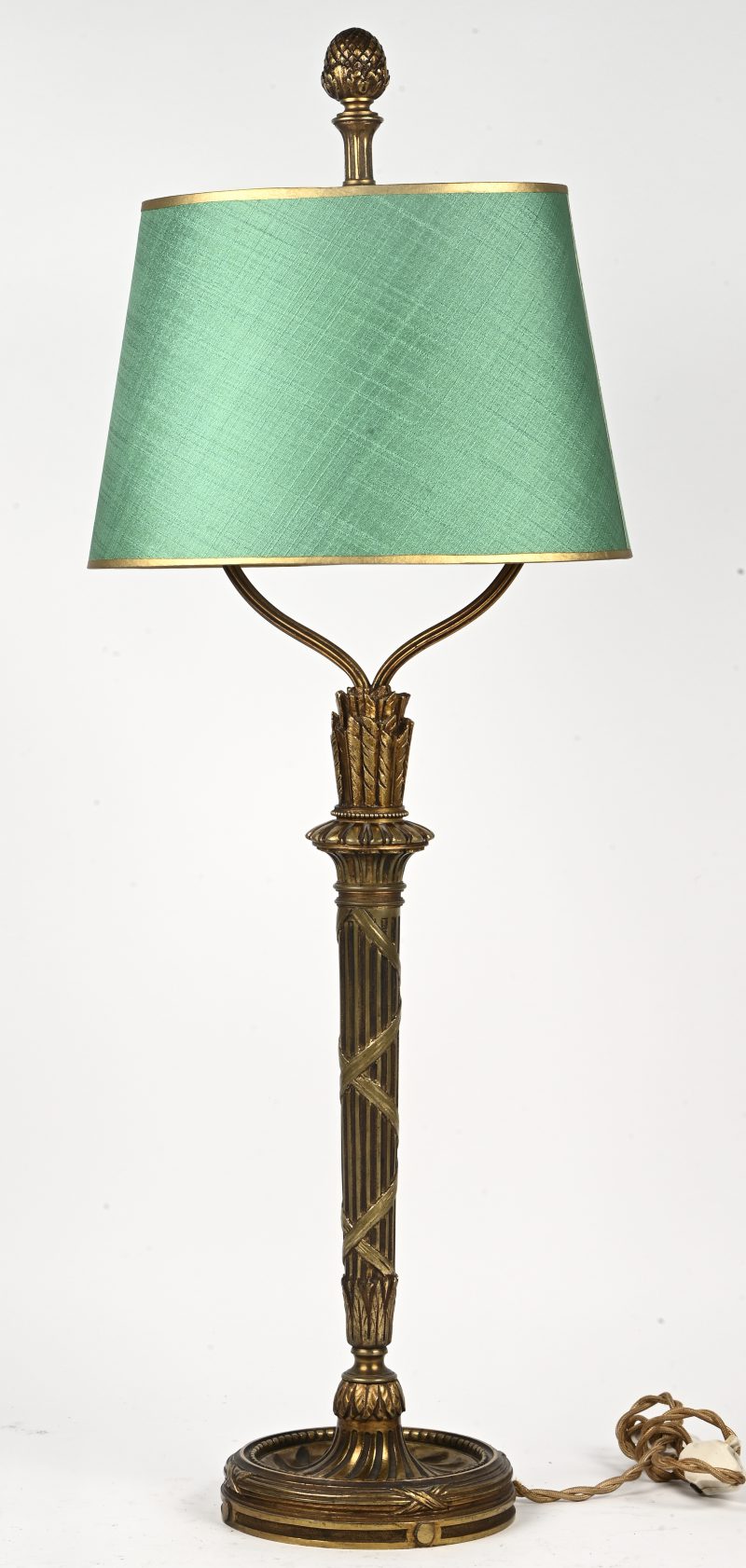 Een messing lampvoet in Hollywood Regency-stijl met groen stoffen kap.