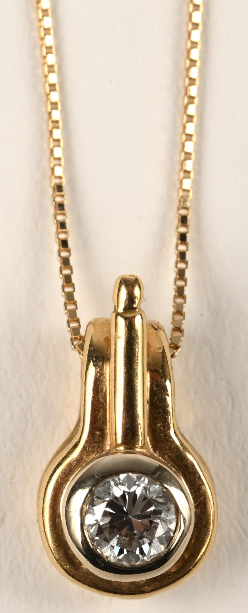 Een 18 karaats geelgouden halsketting met hanger bezet met een centrale briljant van +- 0,29 ct.