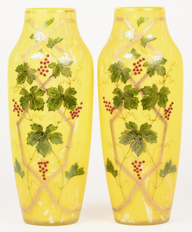 Een paar gele glaspasta vazen met decoratie van druivenranken.