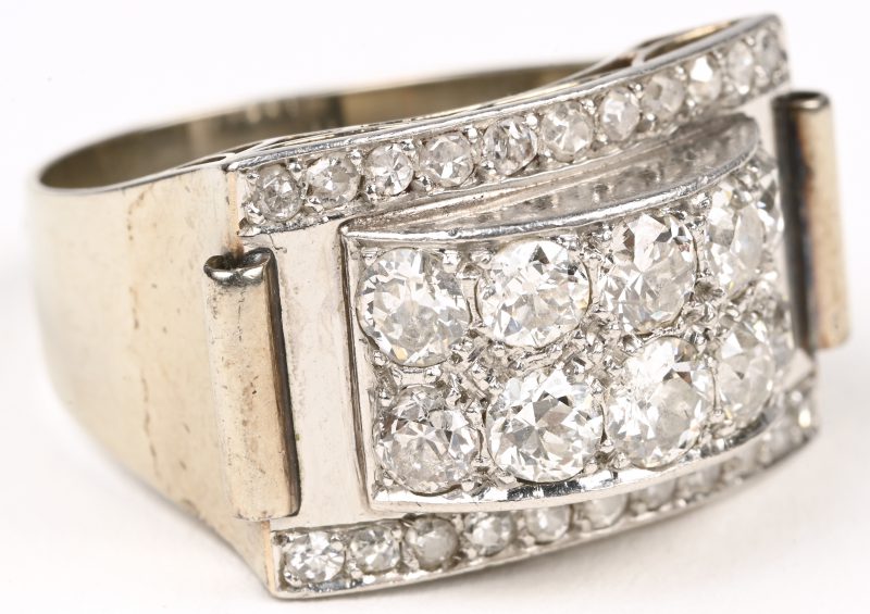 Een 18 karaats witgouden art deco ring bezet met 10 diamanten oude briljant slijp met een gezamenlijk gewicht van +- 2 ct. GP1 en 22 diamanten oude slijp met een gezamenlijk gewicht van +- 0,40 ct.