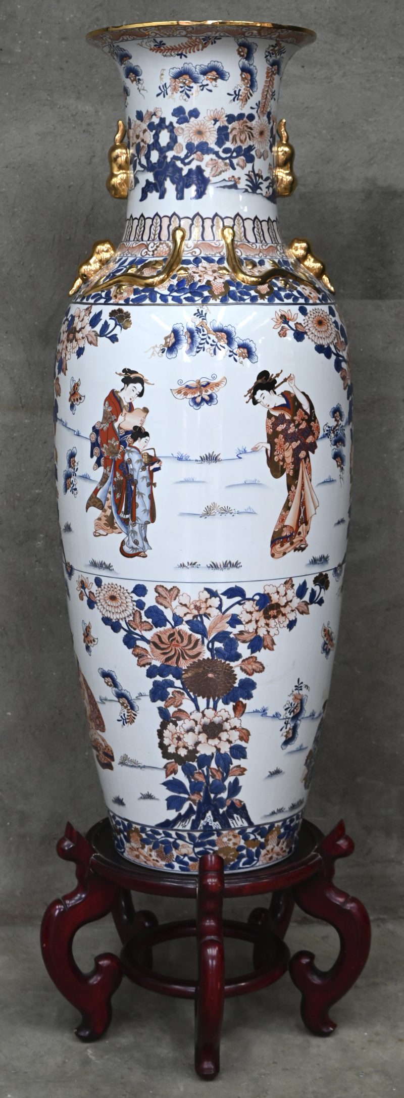 Een zeer grote Chinese vaas op sokkel beschilderd met bloemen en figuren.