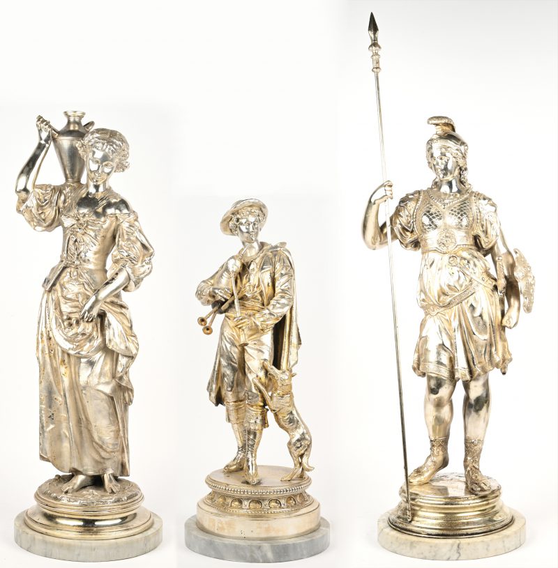 Een set van 3 verchroomde beelden oorstellend een romijnse krijgster, een dame met kruik en een man met doedelzak en hond, allen op ronde marmeren voet.