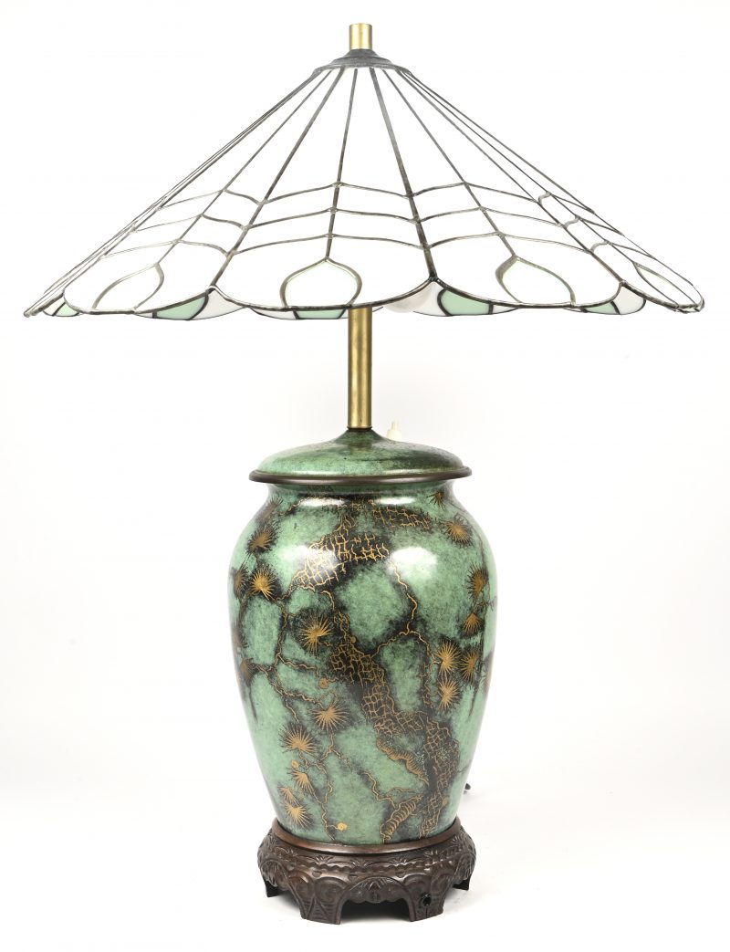Een oosterse stijl koperen lampvoet met florale decoratie gecombineerd met een tiffany-stijl lampekap.
