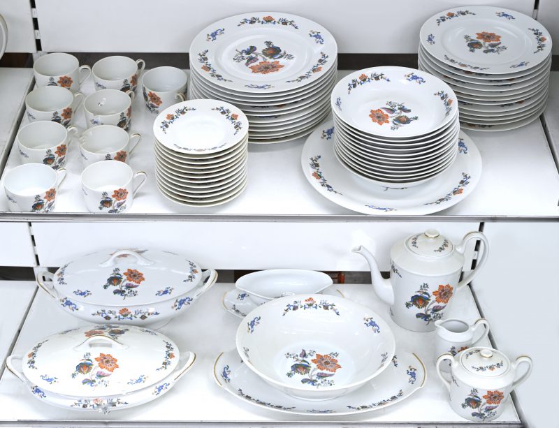 Een handbeschilderd Limoges porselein servies. Medio ‘50, gesigneerd D’Artois. 66 stuks, 5-tal kopjes met lichte breuklijn en enkel bordje met schilferschade aan de rand.