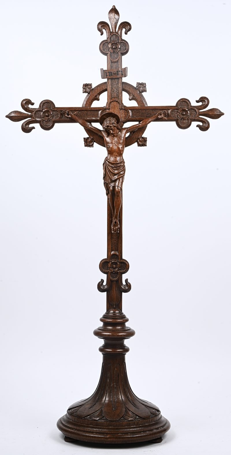 Een neogotisch kruisbeeld van gebeeldhouwd eikenhout.
