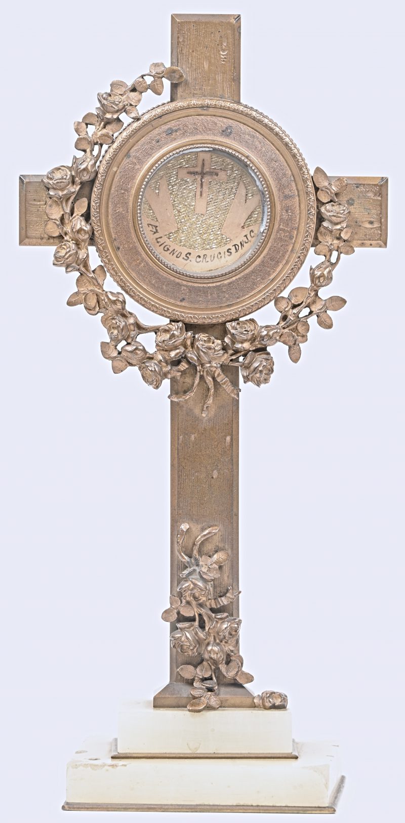 “Ex Ligno SS Crucis D.N. Jesu Christi”. Een bronzen kruisbeeld met een reiiekhouder met splinters van het Kruis van Christus. Albasten voetstuk.