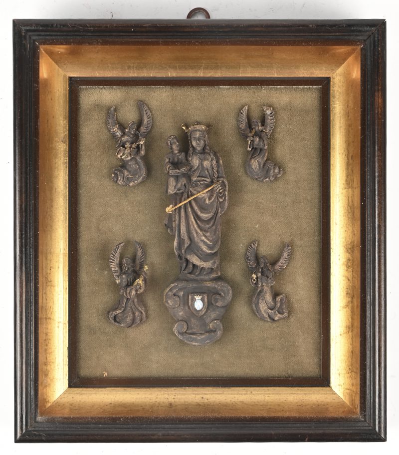 Een kleine Madonna met Kind van gebeeldhouwd hout, omringd door vier engelen en achter glas ingelijst. Vergulde details en met wapenschildje.