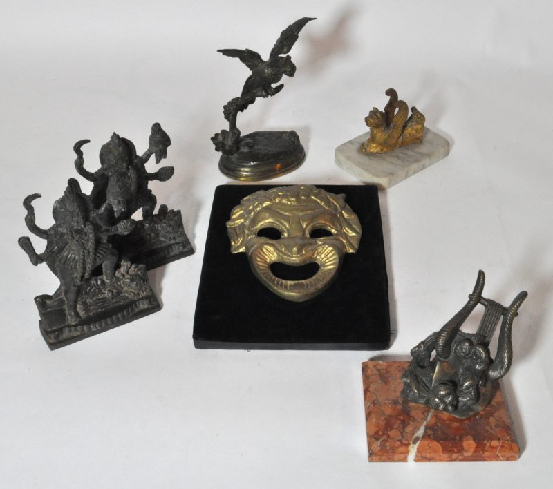 Een divers lot brons, bestaande uit Indische heiligenafbeeldingen, een vogel op een tak, een gevleugelde leeuw, een lier en een masker.