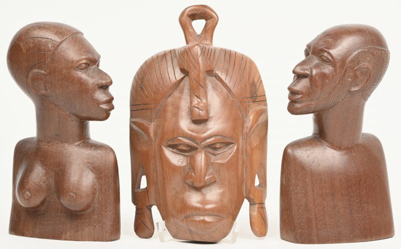 Een gesculpteerd houten etnisch masker, muurdeco. Barstjes aan de oorlellen en een paar hout gesculpteerde boekensteunen met een Afrikaans type man en vrouw.