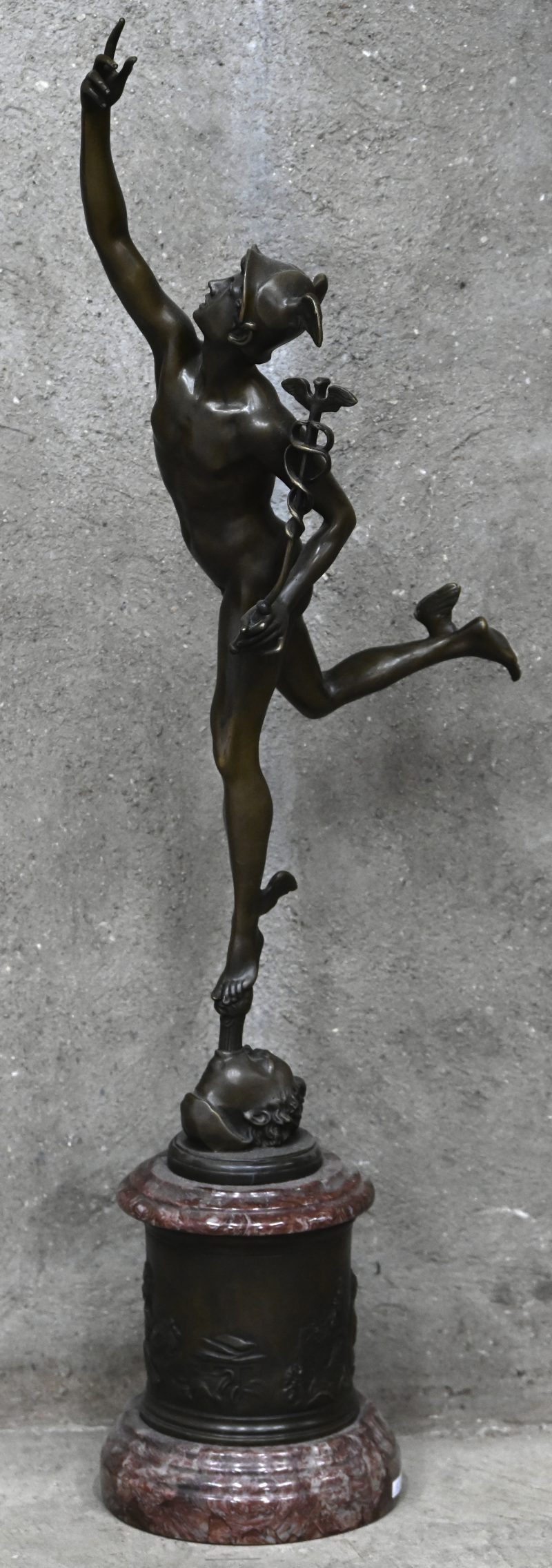 “Mercurius”. Een bronzen beeld op sokkel van rood marmer met bronzen fries. Naar een werk van Jean Bologne. Fijne geut.