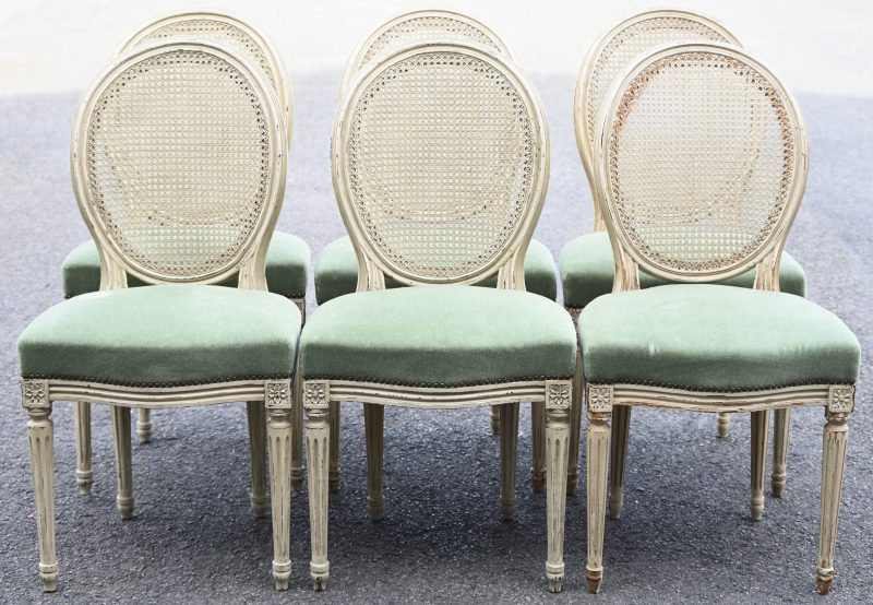 Een lot van 6 Louis XVI stijl stoelen. Ecru gepatineerd met groene velour zitting en cannage rug.