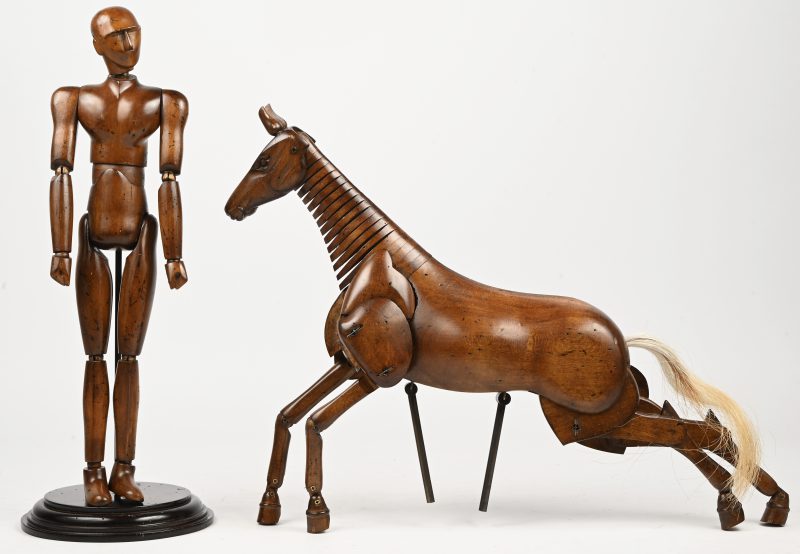 Twee notenhouten tekenaarsmodellen, waarbij één in de vorm van een man en het andere in de vorm van een paard. Het paard zonder sokkel.