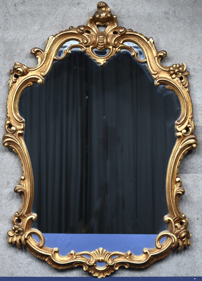 Een spiegel met een vergulde houten kader.