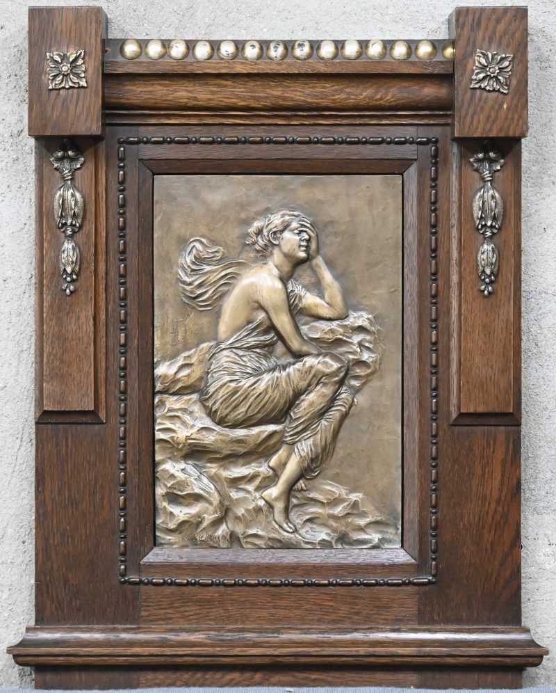 ”Gesluierde dame”. Een bronzen plaquette in houten kader, onderaan gesigneerd.
