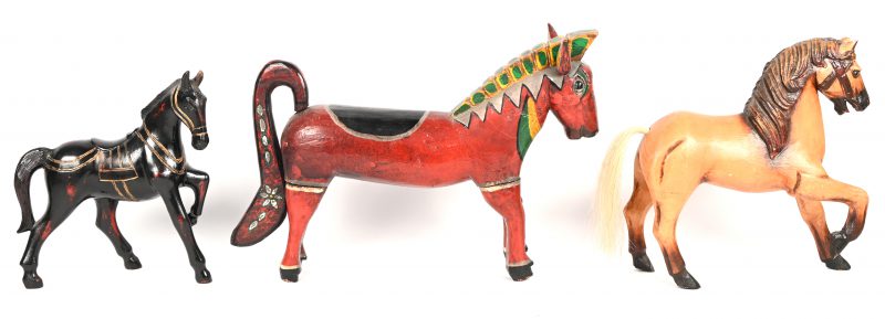 Een lot van 3 houten paarden, de rode heeft afneembare poten en staart, de zwarte en de lichtbruine zijn uit 1 stuk.