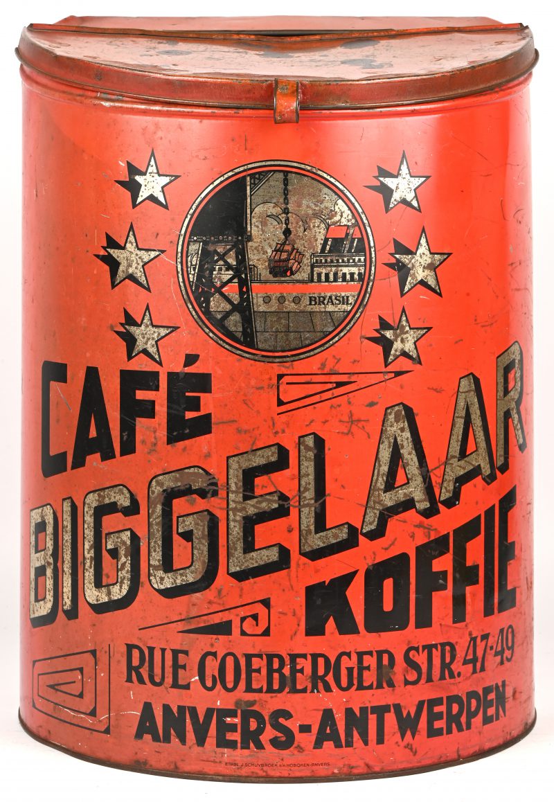 Een groot halfcilindervormig koffieblik, met opschrift “Café Biggelaar”. Rood, zwart en goud kleuren. Vervaardigd door “Établ. J. Schuybroek s.a. Anvers”.