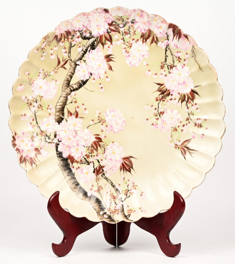 Een Japans porseleinen gelobt celadon bord, 19de eeuw. Met handgeschilderd decor van bloesems. Onderaan gemerkt.