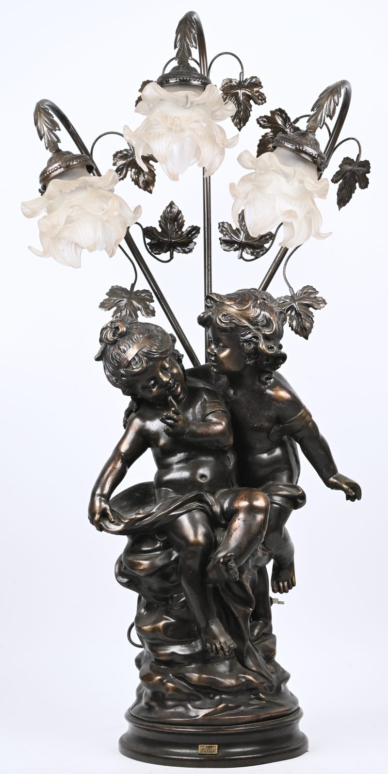 Een brons-look beeld van een zeer jong koppeltje met 3 bloemvormige glazen blakers. Draagt stempel.