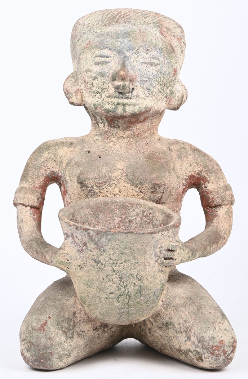 Een aardewerken beeld in precolumbiaanse stijl van een vrouw met mand.