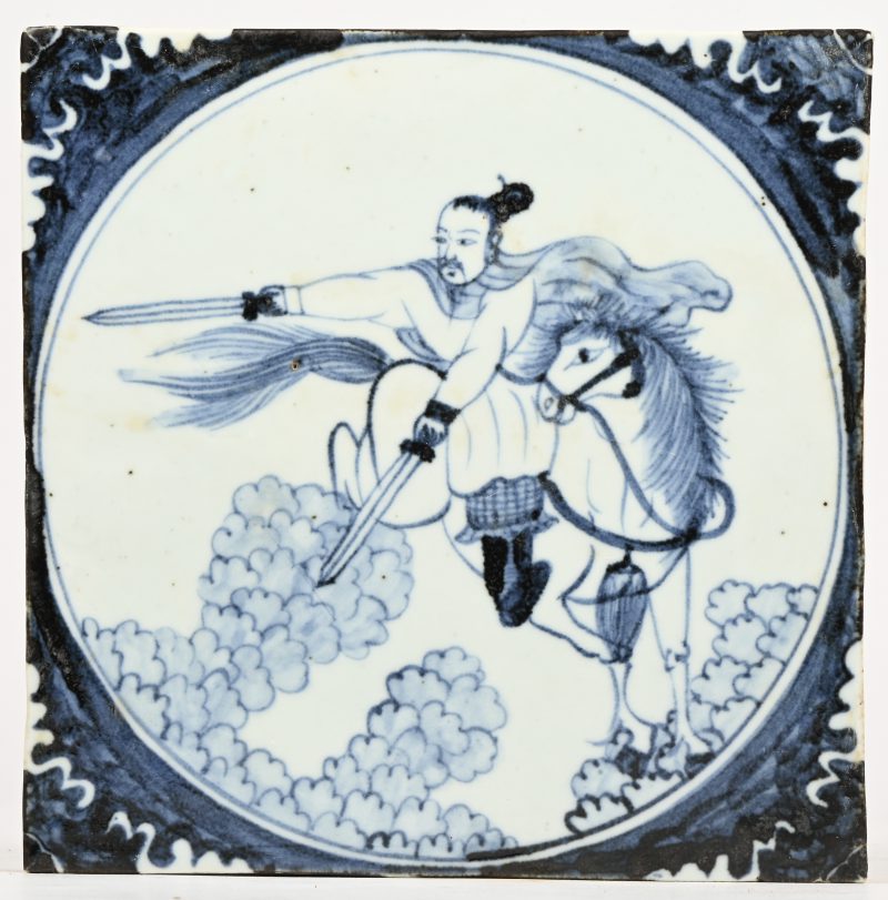 Een blauw en wit Chinees porseleinen tegel met decor van een strijder te paard.