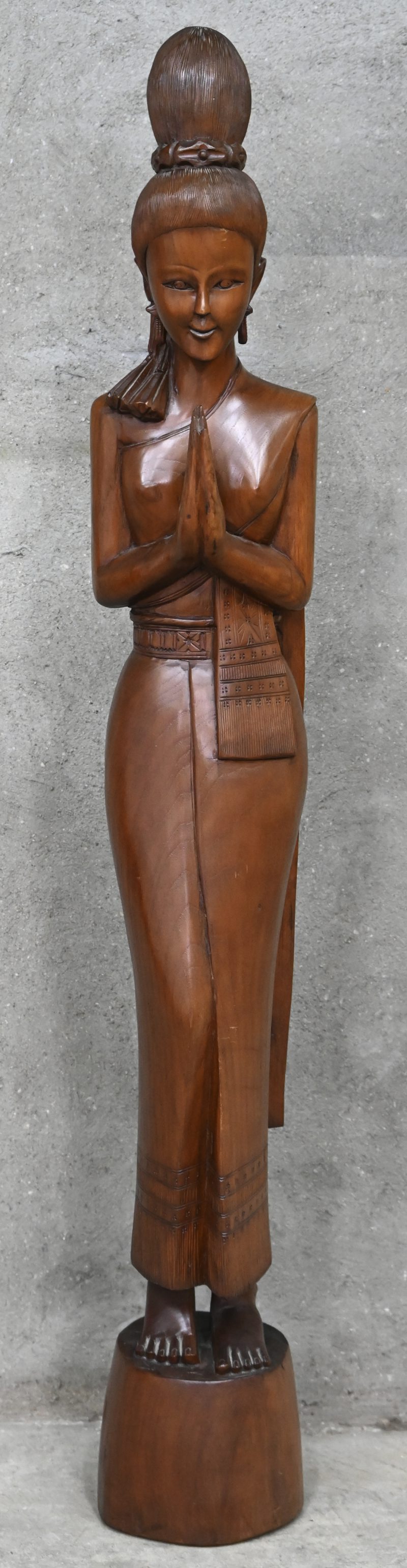 Een houten beeld van een Thaise vrouw.
