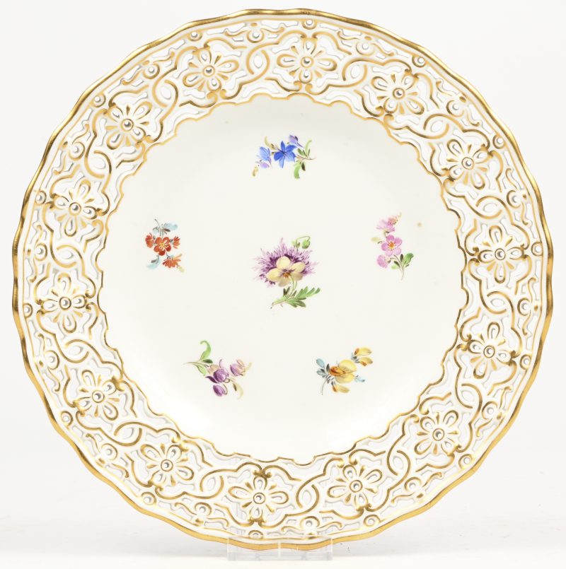 Een porseleien bord met kartelrand en bloemdecor. Achter gemerkt en genummerd Meissen.