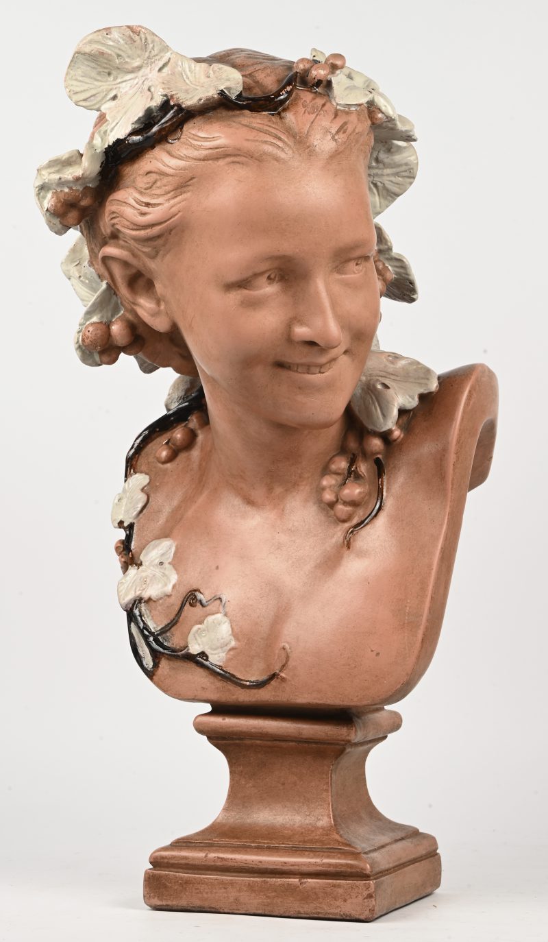 Een plaasteren buste van een mysterieus lachende jongedame in Art-Nouveau stijl.