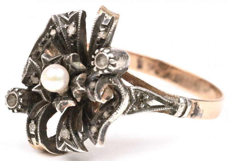 Een 18 karaats roze gouden en zilveren ring bezet met diamant schilfertjes en een parel.