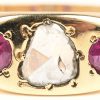 Een 18 karaats geelgouden ring bezet met één diamant oude slijp van +- 0,50 ct. en twee robijnen met een gezamenlijk gewicht van +- 0,30 ct.