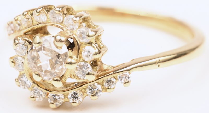 Een 18 karaats geelgouden ring bezet met één centrale diamant van +- 0,25 ct. en briljanten met een gezamenlijk gewicht van +- 0,20 ct.