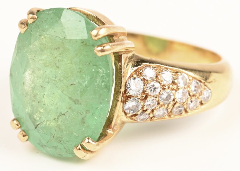 Een 18 karaats geelgouden ring bezet met een Colombiaanse smaragd van +- 9 ct. en briljanten met een gezamenlijk gewicht van +- 0,50 ct.
