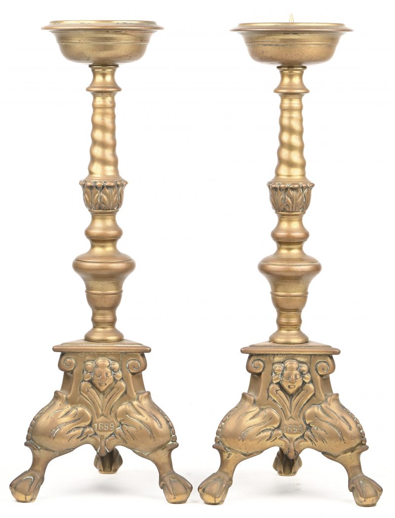 Een paar driepotige kandelaars in brons met bal-en klauwpoten en gesierd met cherubijnhoofdjes.