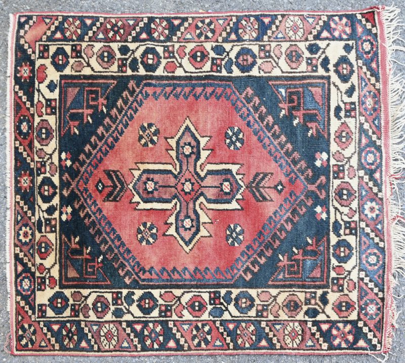 Een handgeknoopt Oosters karpet van wol met een geometrisch motief.