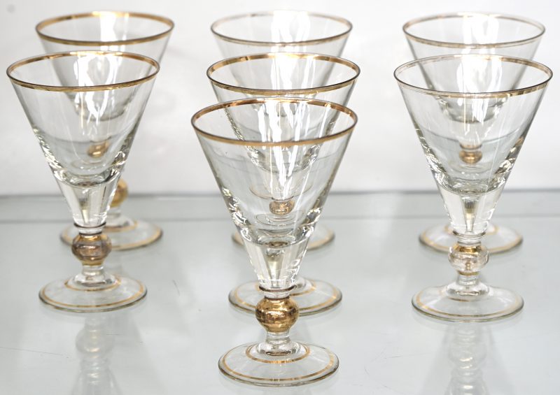 Een set van 7 art deco stijl glazen met vergulde rand en bol aan de voet.