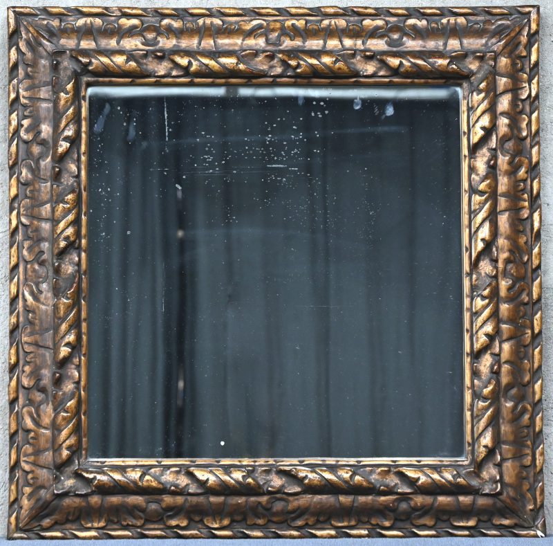Een vierkante spiegel in gesculpteerd en verguld houten kader.