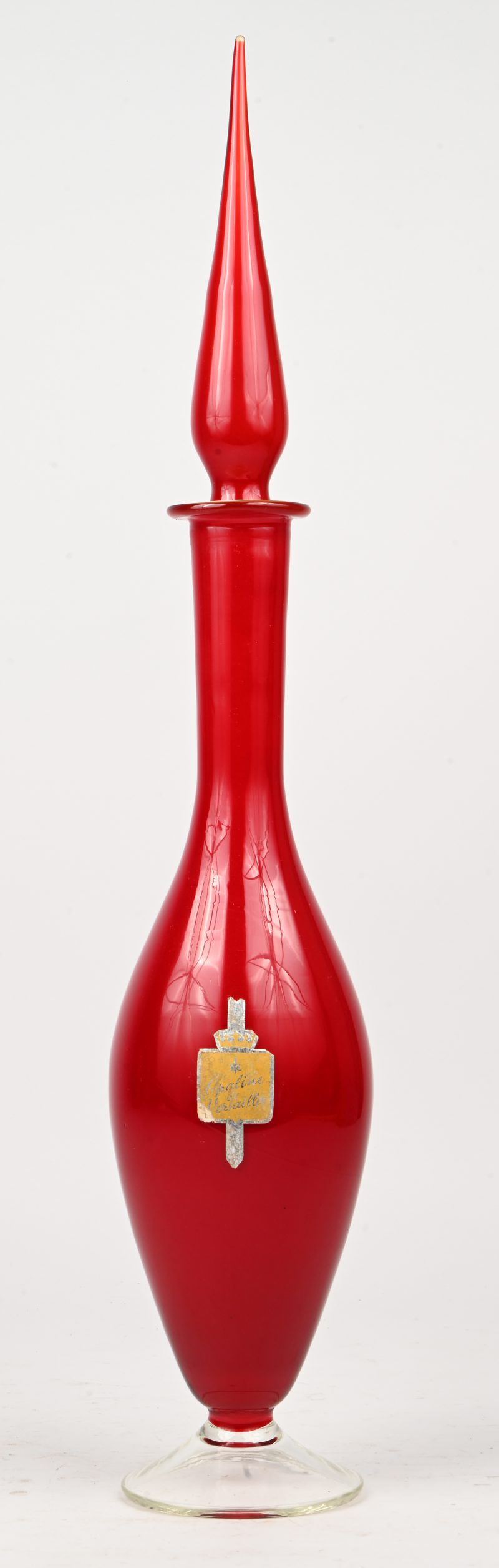 Een rode vintage opaline sierkaraf met sticker waarop vermeld ‘Opaline de Versailles’.