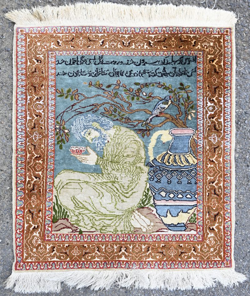 Een handgeknoopt Perzisch karpet van zijde. Met een Arabische tekst.
