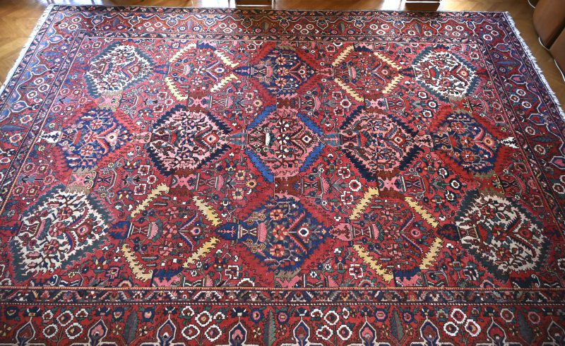 Een groot handgeknoopt Perzisch tapijt.